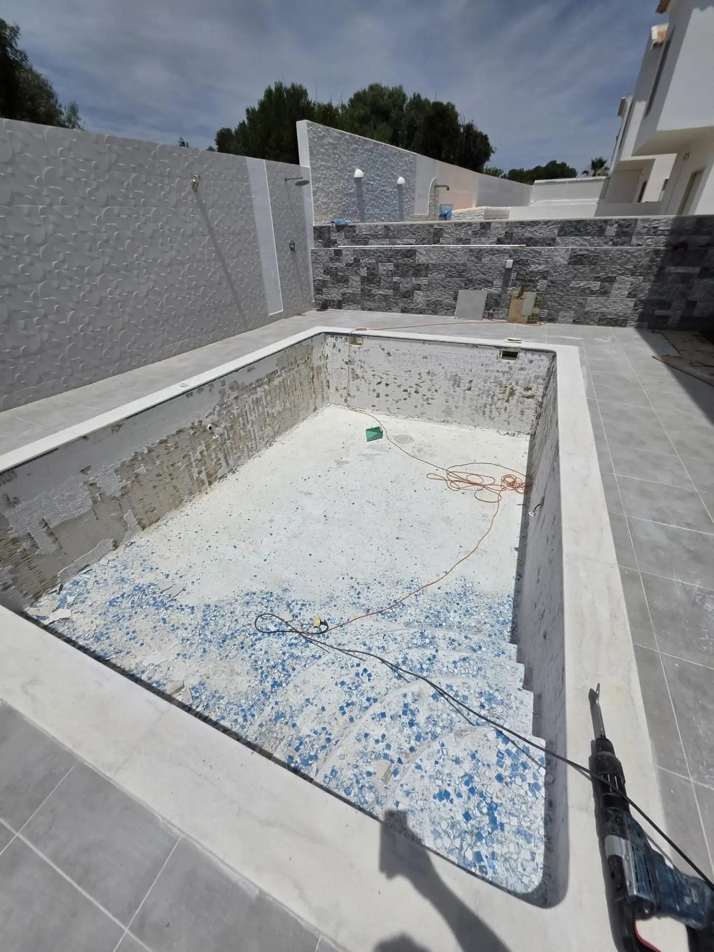 Piscina com mosaico antigo removido antes da renovação